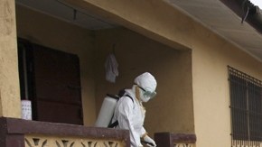 Enfermeros llevan el cuerpo de una víctima del ébola a las afueras de Monrovia, en Liberia.