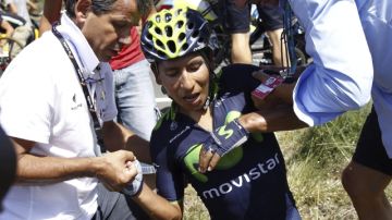 El pedaleador colombiano Nairo Quintana (c) es ayudado tras la caída en el kilómetro 20 de la etapa de ayer.