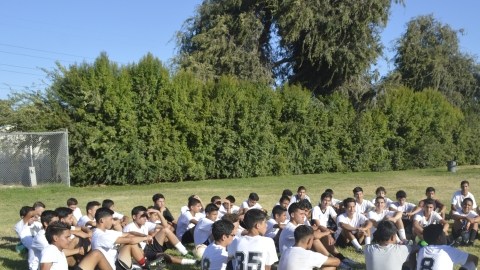 Martín Meza (de pie a la derecha) conversa con los jugadores de la High School de South Gate, alguno de ellos también son parte de Vaqueros Academy.