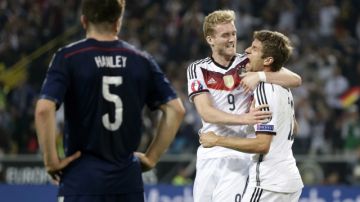 Andre Schurrle abraza a Thomas Muller luego de que este anotara un gol ante Escocia en las eliminatoria de la Euro.