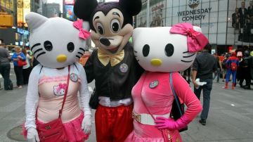 El peruano Miguel, quien anda disfrazado de Mickey Mouse, junto a dos compañeras de trabajo en Times Square.