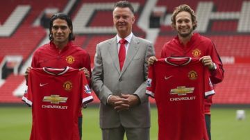 Radamel Falcao (izq) y Daley Blind (d), acompañados por el entrenador Louis van Gaal (c), tras ser presentados ayer por el Manchester United.