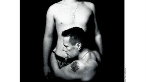 El baterista Larry Mullen Jr. sin camisa y arrodillado, abraza a su hijo, Aaron Elvis.
