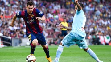 Lionel Messi  (izq.) escapa en velocidad a la marcación de  Javi Márquez del Granada durante el partido disputado  ayer  en el Estadio Camp Nou.
