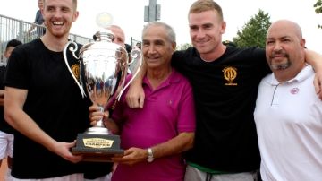 Sal Rapaglia (camisa rosada) y su hijo del mismo nombre (derecha) entregan la Copa al capitán del cuadro campeón.