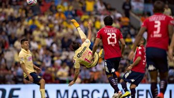 El jugador del América, Pablo Aguilar, se tiende en el aire para rematar un balón.