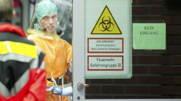 Un trabajador hospitalario con traje protector entra en una habitación de aislamiento del Hospital Uniklinik de Frankfurt, Alemania, tras el ingreso de un miembro de una organización de ayuda humanitaria contagiado con el virus del ébola.
