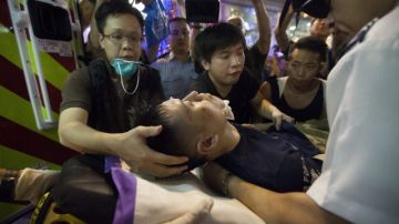 Un joven a favor del movimiento prodemocrático  en Hong Kong recibe atención médica tras resultar herido por  personas en contra de las protestas.