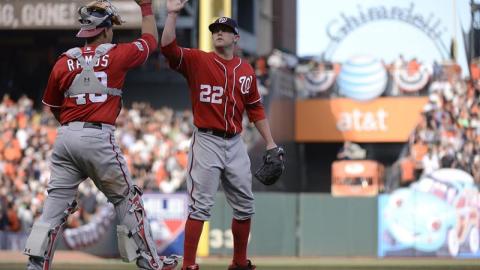 Drew Storen (c) y Wilson Ramos (i) de los Nacionales celebran su anotación ante los Gigantes, durante el juego tres de la Liga Nacional.