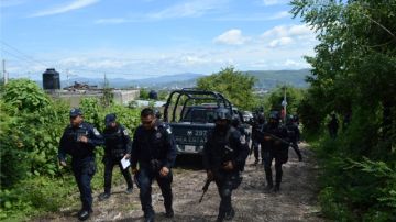 Policías estatales ingresan a la colonia La Parota, situada a las afueras de la ciudad de Iguala, donde fueron halladas varias fosas.