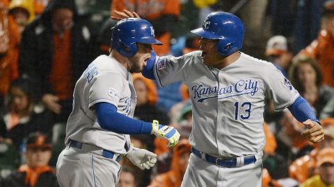 Mike Moustakas (i) y Salvador Perez de los Kansas City Royals celebran tras el vuelacercas de dos carreras de Moustakas contra los Orioles Baltimore en el décimo inning.