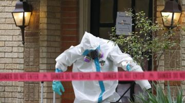 Un equipo de trabajadores especializado en materiales peligrosos  limpia fuera de la vivienda, donde vive la enfermera  que dio positivo al ébola en Dallas.