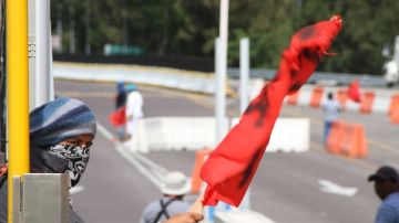 Familiares y compañeros de los estudiantes desaparecidos se tomaron un peaje en la autopista a Acapulco.