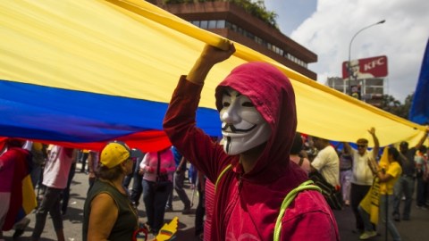 Un joven enmascarado participa en la marcha de la oposición contra de la violencia y la inseguridad; mientras que los chavistas promovieron su rechazo al terrorismo.