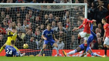 Robin Van Persie toma el rebote del portero Thibaut Courtois de Chelsea para anotar el gol del empate de Manchester United ayer en Old Trafford.