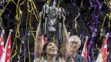Serena Williams alza feliz el trofeo  Billie Jean King en una ceremonia especial.