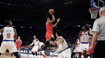 El defensor de Chicago Bulls Derrick Rose (c) salta para encestar contra los New York Knicks.