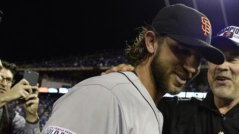 El lanzador de Gigantes Madison Bumgarner (i) conversa con el técnico Bruce Bochy (d).
