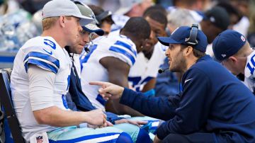 Tony Romo (der.), fuera por lesión, charla con su suplente Brandon Weeden en la banca de los Cowboys durante el partido contra Arizona.