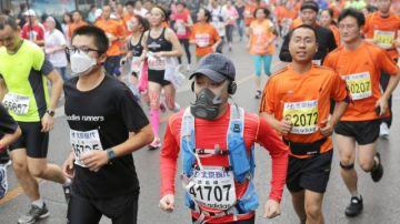 Corredores se protegen del smog para participar en el maratón de Beijing 2014. Algunos incluso tuvieron que abandonar la carrera.