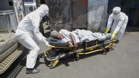 Personal médico transporta a un hombre de 70 años con síntomas de ébola en Liberia.