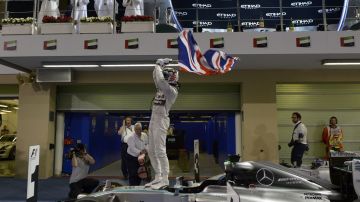 Felipe Massa (i) y Valtteri Bottas (d) festeja en el podio con el nuevo campeón Lewis Hamilton.