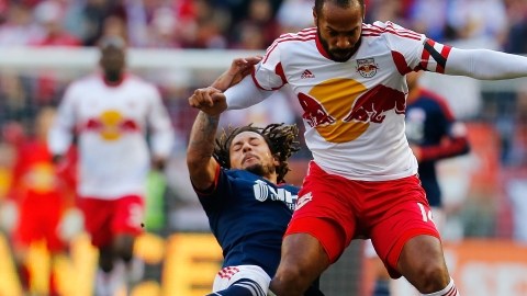 Thierry Henry supera la barrida defensiva de  Jermaine Jones    de New England.
