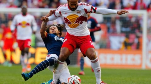 Thierry Henry supera la barrida defensiva de Jermaine Jones de New England.