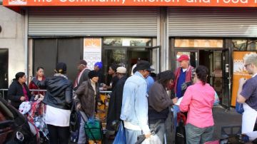 Decenas de personas se acercaron el lunes al Food Bank en la calle 116 para recibir bolsas de alimentos.