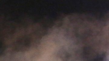 Un agente de Ferguson apunta a la multitud con botes de gas en agosto pasado.