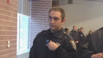 Oficiales muestran las cámaras corporales en la Academía de Policía.