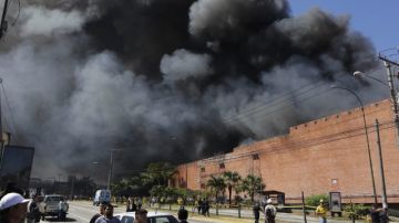 Personal del cuerpo de bomberos salvadoreños trataban de controlar el incendio ayer en el centro comercial.