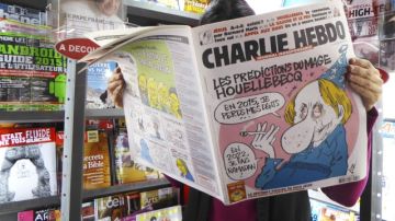 Una mujer lee el último número del semanario satírico "Charlie Hebdo", ayer en un quiosco en París.