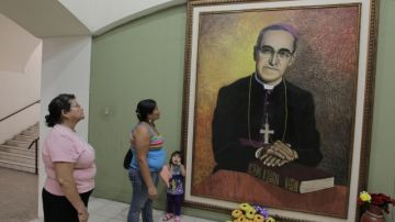 Salvadoreñas observan una pintura del arzobispo de San Salvador Óscar Arnulfo Romero.