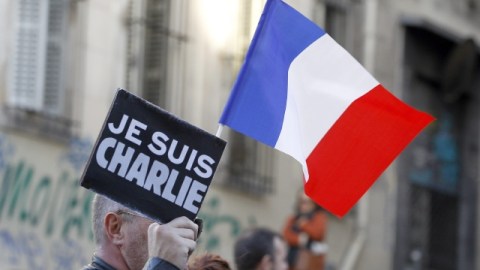 Un hombre con un cartel con el eslogan 'Je Suis Charlie' la bandera francesa participa en una de las múltiples manifestaciones realizadas ayer en toda Francia.