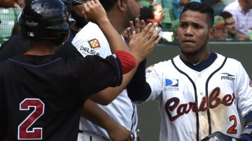 Venezuela National baseball team players celebrate Alexi Amarista(R) scoring the tie run for 2-2 in the 6th inning against the Mexican National.