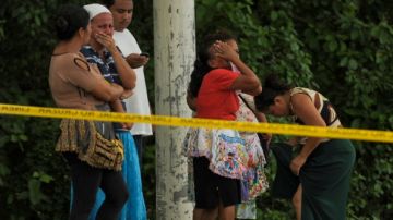 Familiares de una persona asesinada en el asalto a un autobús en San Luis Talpa, El Salvador.