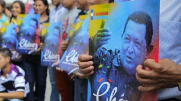 Salvadoreños sostienen imágenes del expresidente de Venezuela, Hugo Chávez.