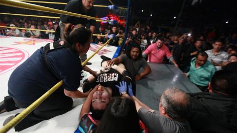 El luchador mexicano "El Hijo del Perro" Aguayo" (c) recibe atención tras recibir una patada voladora de su rival, Rey Misterio.