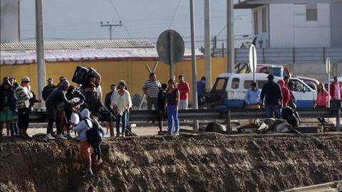 Personas afectadas cruzan el caudal del río formado tras las inundaciones torrenciales en Chañaral, al norte de Chile.