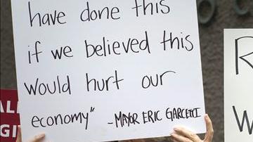 Trabajadores de restaurantes de comida rápida sostienen pancartas durante una protesta para aumentar los sueldos.