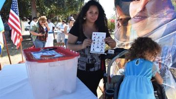 Maya Batres (i) muestra su papeleta electoral en las elecciones presidenciales simbólicas de la comunidad guatemalteca en Estados Unidos, en Los Ángeles, California