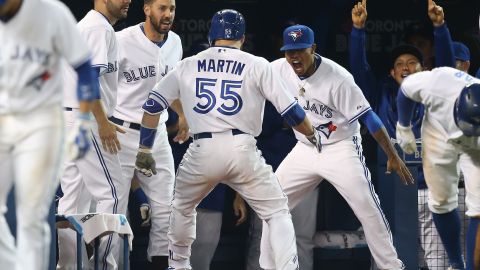 Russell Martin es felicitado en la caseta de los Azulejos luego de su jonrón decisivo en la séptima entrada.