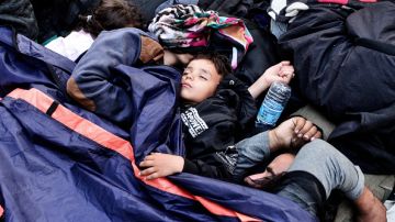 Un niño duerme entre otros refugiados en Victoria Square, Atenas, Grecia.
