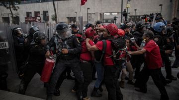 Manifestantes chocan con la policía antidisturbios tras una manifestación para pedir continuar con la búsqueda de los 43 estudiantes secuestrados el 26 de septiembre de 2014.