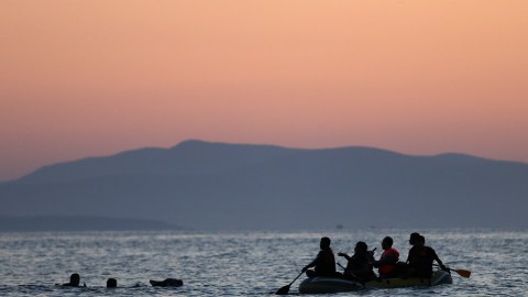 Dos inmigrantes de Siria son rescatados por otros en un bote cerga ce las costas de Grecia.