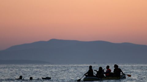 Dos inmigrantes de Siria son rescatados por otros en un bote cerga ce las costas de Grecia.