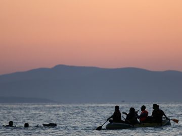 Dos inmigrantes de Siria son rescatados por otros en un bote cerga ce las costas de Grecia.