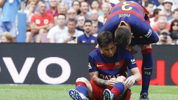 El delantero argentino  Leo Messi (i) es animado por Gerad Piqué después de lesionarse durante el partido de la sexta jornada de Liga en Primera División entre el FC Barcelona y la UD Las Palmas disputado en el Camp Nou, el pasado 26 de septiembre.