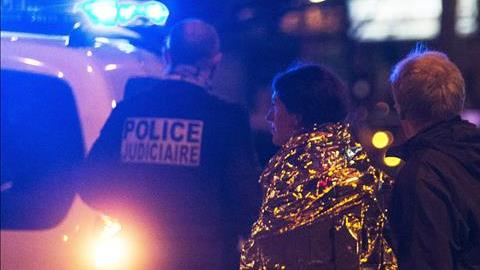 Dos personas son escoltadas por la policía francesa junto a la discoteca Bataclan.